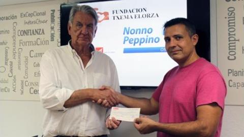 Darío Alonso (izquierda), tesorero de la Fundación Txema Elorza, entrega el cheque al tesorero de Apadrina una Neurona, Javier Agudo.